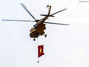 Вертолеты Ми с национальным флагом и истребители Су-30МК2 тренируются в небе над Ханоем