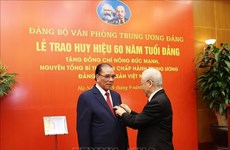 Вручение значка «60-летнего членства Партии» бывшему генеральному секретарю ЦК КПВ Нонг Дык Маню