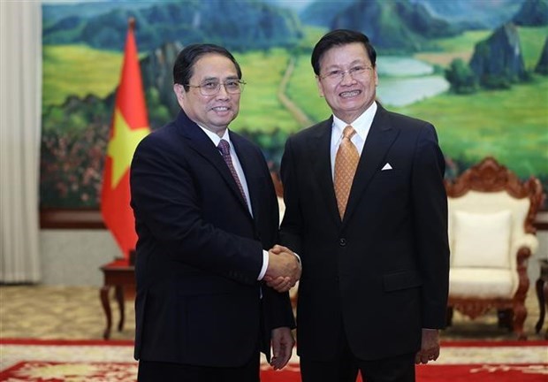 Премьер-министр Фам Минь Тьинь встретился с генеральным секретарем ЦК НРПЛ и президентом Лаоса Тонглуном Сисулитом hinh anh 1