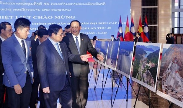 Премьер-министры Вьетнама и Лаоса посетили фотовыставку, посвященную достижениям экономических связеи hinh anh 1