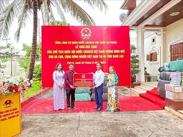 Передача подарков Председателя НС вьетнамцам в четырех южных провинциях Лаоса hinh anh 1