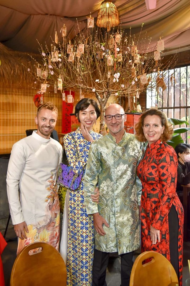 Международные друзя с удовольствием в платьем аозаи испытывают в себе вьетнамскии традиционныи Тэт hinh anh 13