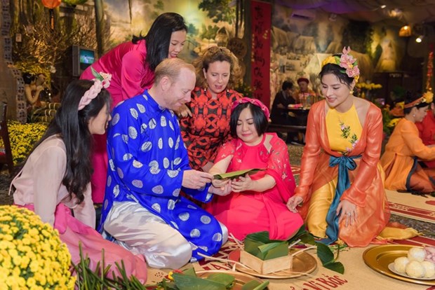 Международные друзя с удовольствием в платьем аозаи испытывают в себе вьетнамскии традиционныи Тэт hinh anh 18