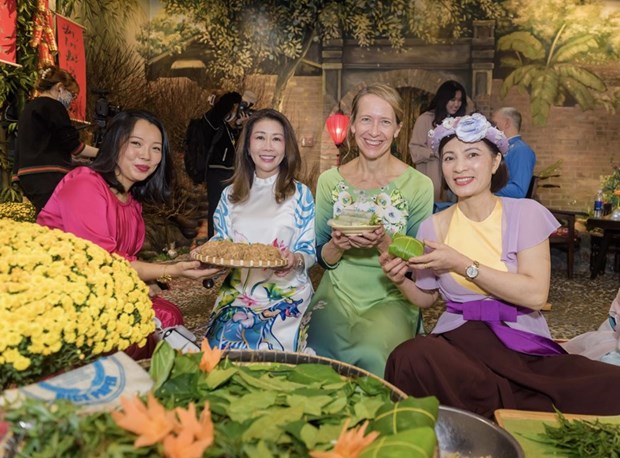 Международные друзя с удовольствием в платьем аозаи испытывают в себе вьетнамскии традиционныи Тэт hinh anh 1