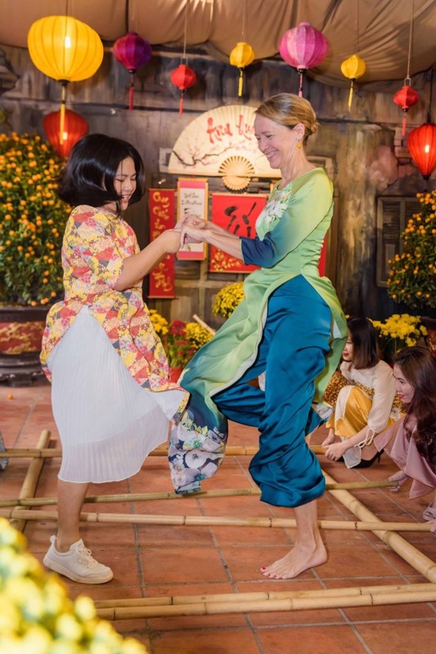 Международные друзя с удовольствием в платьем аозаи испытывают в себе вьетнамскии традиционныи Тэт hinh anh 23