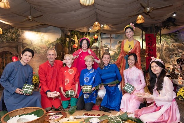 Международные друзя с удовольствием в платьем аозаи испытывают в себе вьетнамскии традиционныи Тэт hinh anh 4