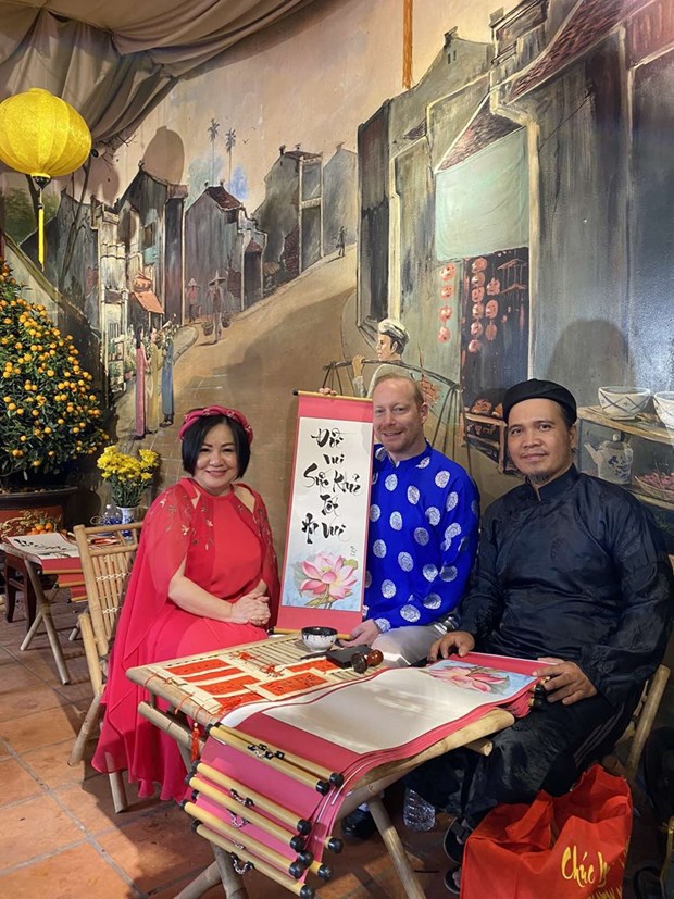 Международные друзя с удовольствием в платьем аозаи испытывают в себе вьетнамскии традиционныи Тэт hinh anh 7